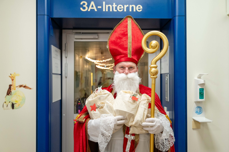 Mann verkleidet als Nikolaus vor einem Stationseingang.