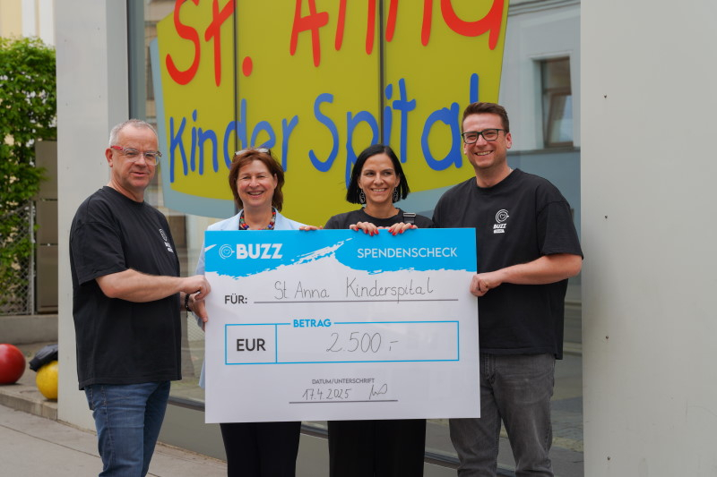 BUZZ-Fitness-Team und Pflegedirektorin halten einen Spendenscheck und lächeln in die Kamera.