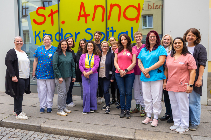 Mitglieder des Schmerz-Teams vor dem St. Anna Kinderspital lachen in die Kamera
