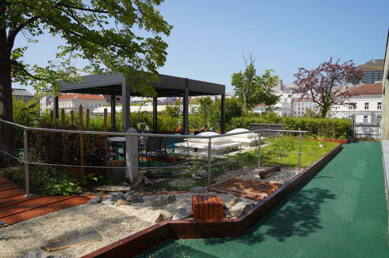 Eine Panoramaaufnahme des begrünten Dachgartens und Sensomotorikwegs im St. Anna Kinderspital