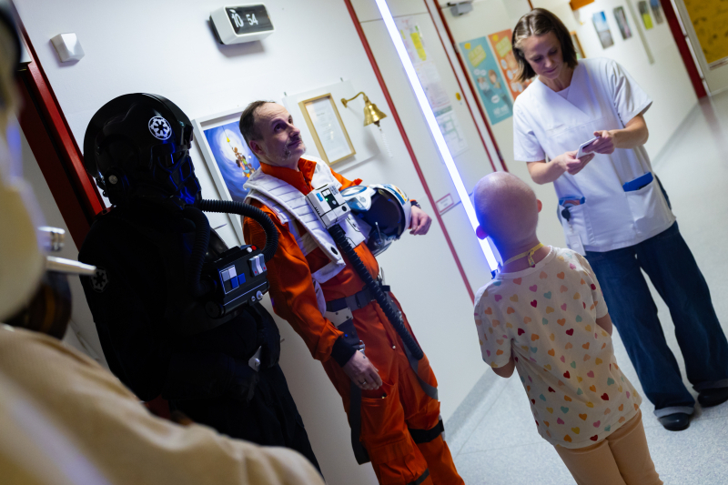 Kleiner Patient hält Laserstab in die Luft.