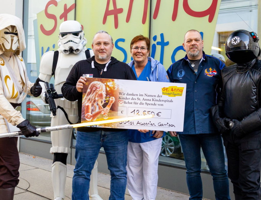 Vertreter*innen der Star-Wars-Kostümclubs „501st Legion Austrian Garrison“ und „Rebel Legion Alpine Base Austria“ mit Stv. Pflegedirektorin Ingrid Gruber bei Scheckübergabe.