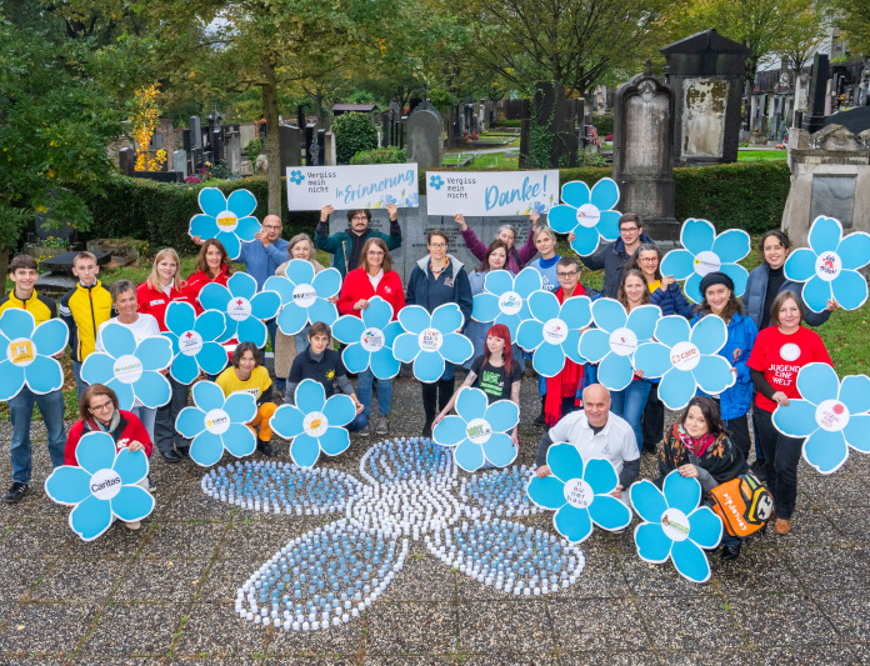 Menschen mit übergroßen ausgedruckten blauen Blumen