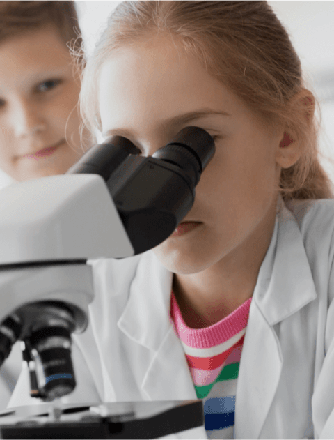 Kinder schauen durch ein Mirkroskop